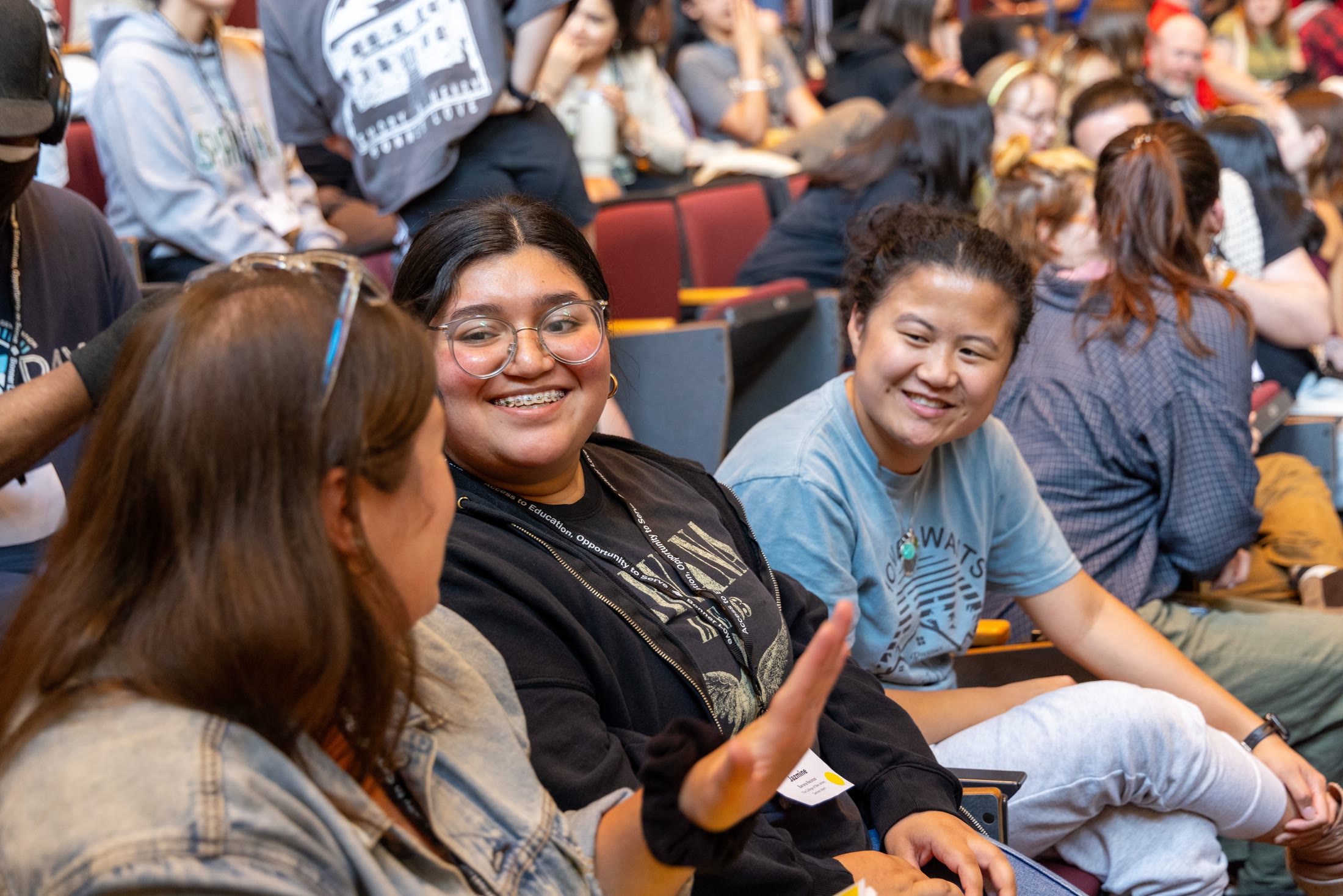 Students talking together in a crowded auditorium