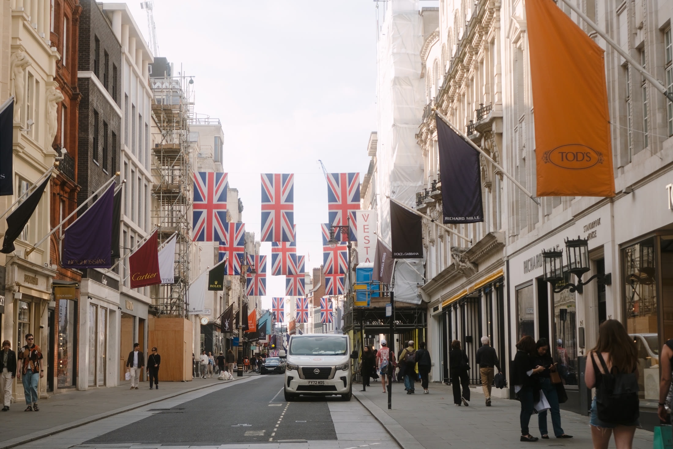A London street lined with Union Jack flags and storefront banners