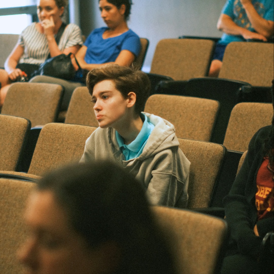 A student seated in an auditorium during an event